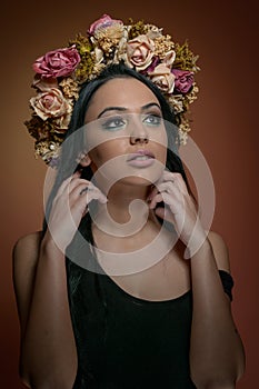 Hairstyle and Make up - beautiful female art portrait with wreath of roses, studio.