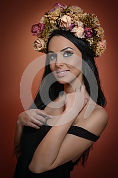 Hairstyle and Make up - beautiful female art portrait with wreath of roses, studio. Elegance. Genuine brunette, creative hairstyle