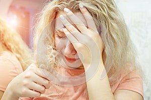 Hairstyle portrait in shock; beautiful blonde girl with long hair looking at split ends