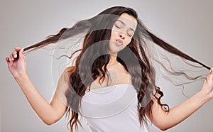 Hairstyle, strand and woman with curly hair in studio for treatment, cosmetics or shampoo on white background. Texture