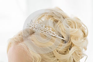 Hairstyle with a tiara crown. Hair dressing for the bride with a crown tiara. The precious crown on the hair of the girl.