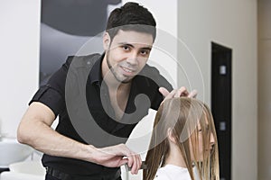 Hairstylist Combing Client's Hair At Salon