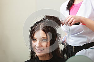 Hairstylist drying hair woman client in hairdressing beauty salon