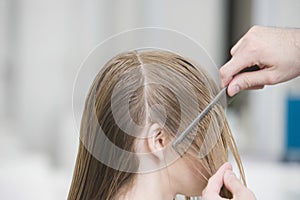 Hairstylist's Hand Combing Client's Hair Before Haircut In Salon