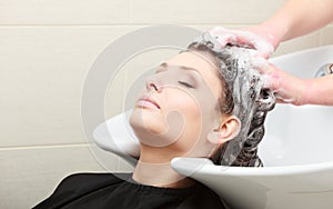 Hairstylist washing woman hair. Hairdressing beauty salon