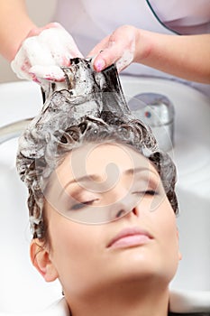 Hairstylist washing woman hair. Hairdressing beauty salon