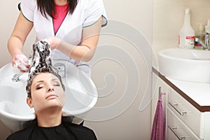 Hairstylist washing woman hair. Hairdressing salon