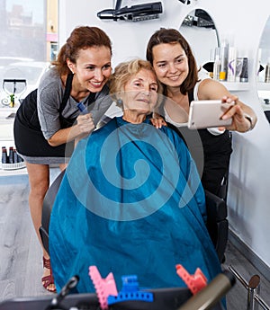 Hairstylists and female customer taking selfie