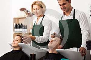 Hairstylists washing the hair of customers