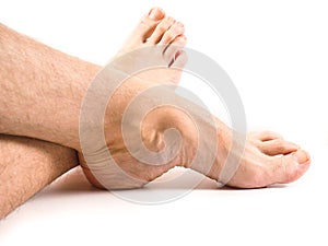 Hairy legs and feet of male person resting one white