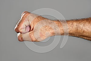 Hairy man fist closeup expression over gray