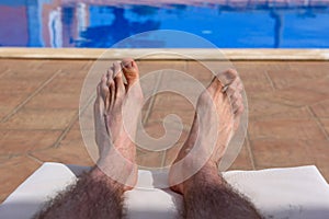 Hairy man`s legs, during taking sunbath.