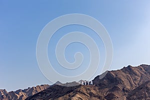 Hajar Mountains range in Hatta, with large Hollywood style Hatta sign on top of the hill, United Arab Emirates.