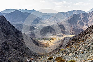 Hajar Mountains and Wadi Ghargur landscape view with transmission towers seen from Copper Hike Summit, UAE