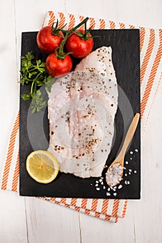 Hake fillet with black peppercorn, tomato, lemon and parsley