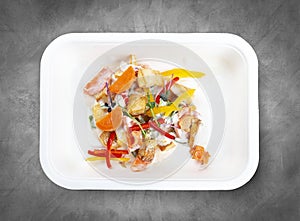 Hake fricassee with vegetables. Healthy diet. Takeaway food. Top view, on a gray background