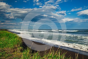 Halaktyr beach. Kamchatka. Russian federation. Dark almost black color sand beach of Pacific ocean. Stone mountains and