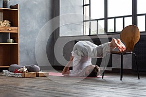 Halasana plough pose by caucasian man working out at home.