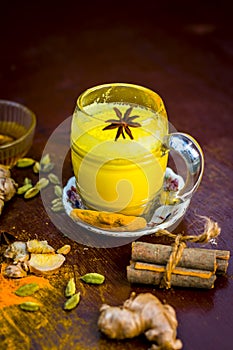 Haldi wala dodh or golden sweetened milk with all spices on wooden surface