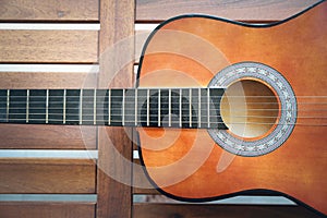 Half acoustic guitar on wooden background