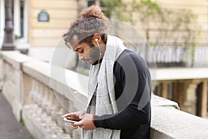 Half African tourist listening to new songs in earphones with sm