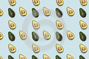 Pattern of half of avokado on blue background.