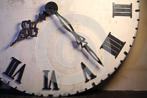 Half of big white clock with Roman dial standing