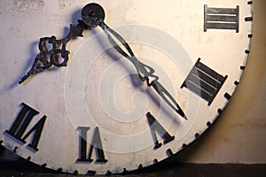 Half of big white clock with Roman dial standing photo