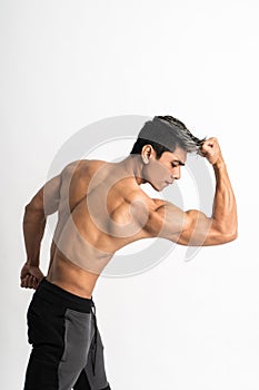 Half body image of young man showing muscular biceps stand facing forward