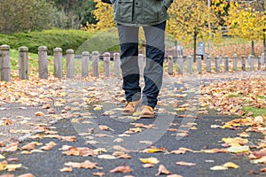 Half body of walking male on autumn footpath.