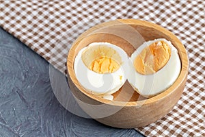 Half boiled eggs on wooden bowl