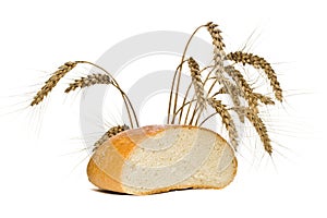 Half of the bread loaf and wheat spikes, isolated