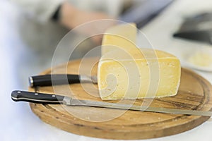 Half cheese head on on wooden market board. Gastronomic dairy produce, real scene in the food market photo