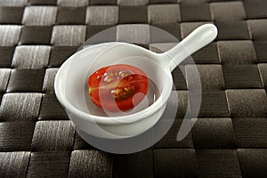 Half cherry tomato in a little dish