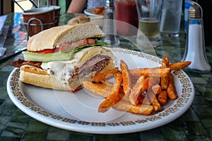 Half chivito sandwich, a traditional snack in Uruguay, served with french fries.