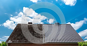 A half cleaned house roof shows the before and after effect of a roof cleaning