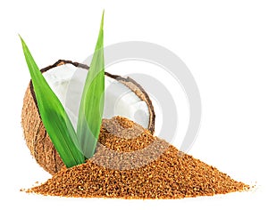 Half of coconut, green palm leaves and brown coconut sugar isolated on white background. Healthy sugar alternative
