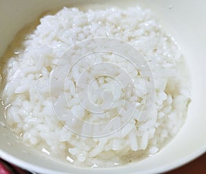 Half-cooked white rice in a white bowl