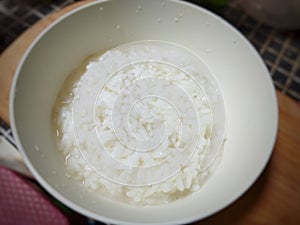 Half-cooked white rice in a white bowl