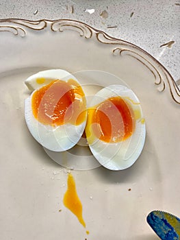 Half Cut Boiled Juicy Egg with Sea Salt in Breakfast Plate. Undercooked