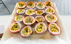 Half cut passion fruits on white plate. Ripe passion fruit isolated on table.