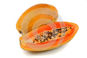 Half cut and whole papaya fruits on white background