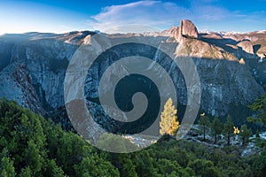 Half Dome and Yosemite Valley in Yosemite National Park during colorful sunset with trees and rocks. California, USA