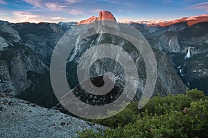 Half Dome and Yosemite Valley in Yosemite National Park during colorful sunset with trees and rocks. California, USA