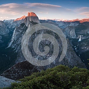 Half Dome and Yosemite Valley in Yosemite National Park during colorful sunset with trees and rocks. California, USA