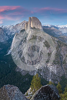 Half Dome and Yosemite Valley in Yosemite National Park during colorful sunset with trees and rocks. California, USA