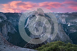 Half Dome and Yosemite Valley in Yosemite National Park during colorful sunset with trees and rocks. California, USA