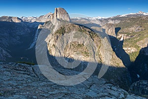 Half Dome and Yosemite Valley in Yosemite National Park during colorful sunset with trees and rocks. California, USA