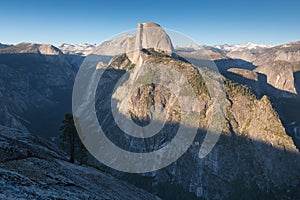 Half Dome and Yosemite Valley in Yosemite National Park during colorful sunset with trees and rocks. California, USA