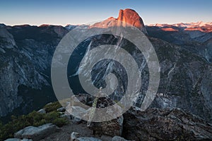 Half Dome and Yosemite Valley in Yosemite National Park during colorful sunset with trees and rocks. California, USA